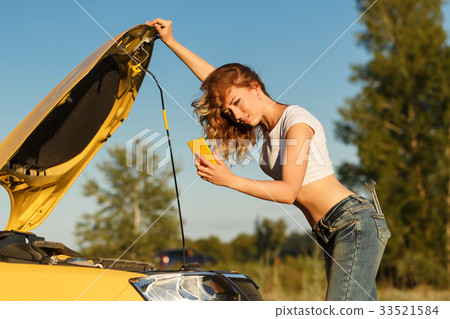 Girl repairing car and on phone 33521584