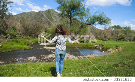 Hiking woman jumping in beautiful landscape nature 33521633