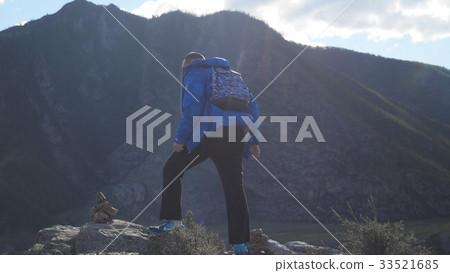 Hiker with backpack hiking on top of a mountain 33521685