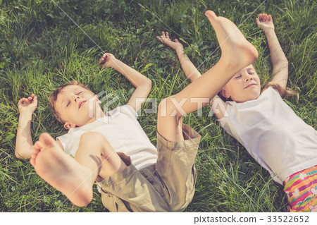 Two happy children playing on the grass at the day time. Two happy children playing on the grass at the day time. 33522652