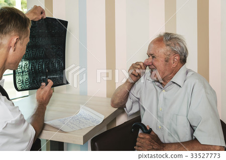 Doctor is reviewing x-ray  photo of the old man. 33527773