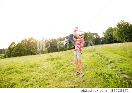 Hipster father and little son on green meadow 33528171