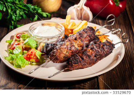 Grilled shish kebab served with fried chips 33529670