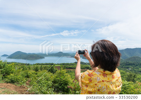 Female traveler with smart phone taking a photo Female traveler with smart phone taking a photo 33530200