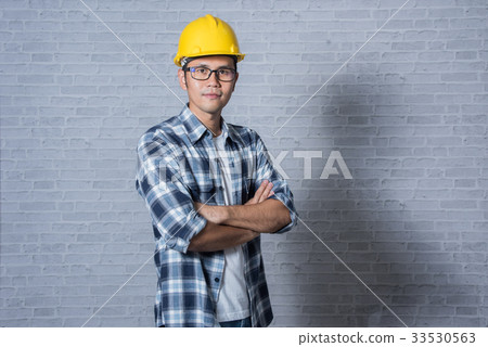 Asia young man in helmet standing with arms cross Asia young man in helmet standing with arms cross 33530563