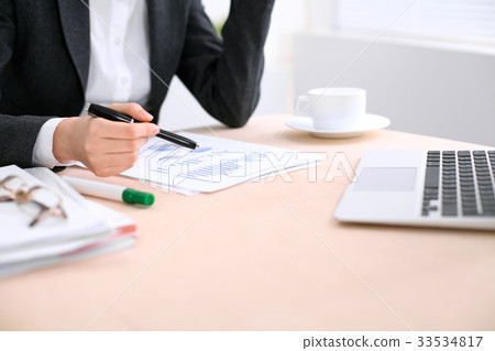 Business woman sitting at the table and examines 33534817