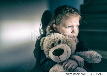 Sad little girl embracing her teddy bear - feels lonely Sad little girl embracing her teddy bear - feels lonely 33535933