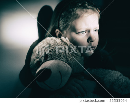 Sad little girl embracing her teddy bear Sad little girl embracing her teddy bear 33535934