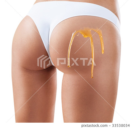 Honey flows down on woman buttocks. Honey flows down on woman buttocks. 33538034
