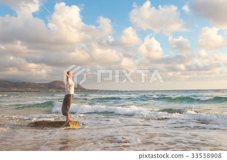 Free Happy Woman Enjoying Sunset on Sandy Beach 33538908