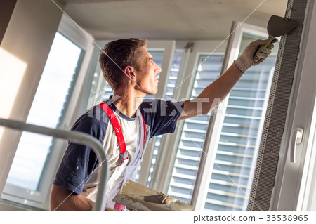 Plasterer renovating indoor walls and ceilings 33538965