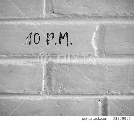 10 P.M. WRITTEN ON WHITE PLAIN BRICK WALL 33539995