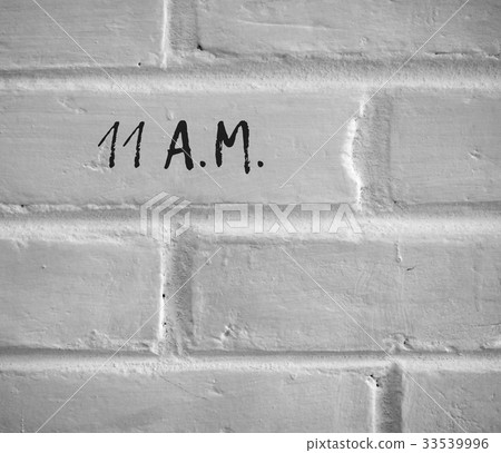 11 A.M. WRITTEN ON WHITE PLAIN BRICK WALL 33539996