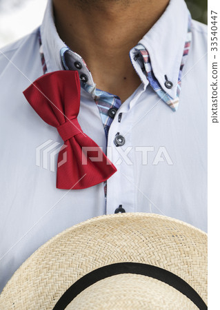 Man in shirt with untied bow-tie and wicker hat 33540447
