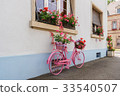A decorative old pink bicycle with a flower basket 33540507
