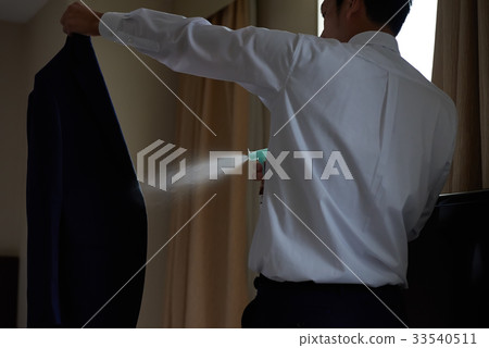 Businessman using a deodorant spray Businessman using a deodorant spray 33540511