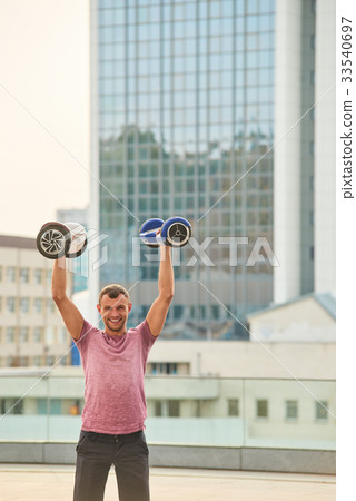 Man holding hoverboards and smiling. Man holding hoverboards and smiling. 33540697