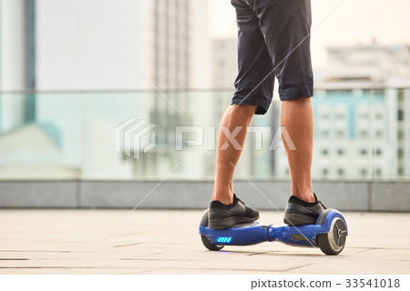 Legs of man riding gyroscooter. 33541018