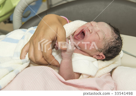 A newborn baby held by a mother A newborn baby held by a mother 33541498