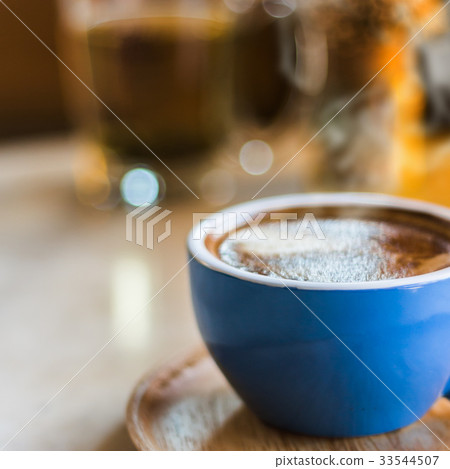 Close up coffee cup with steam on table in cafe. Close up coffee cup with steam on table in cafe. 33544507