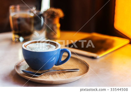 Coffee cup on table with tablet in cafe shop. 33544508