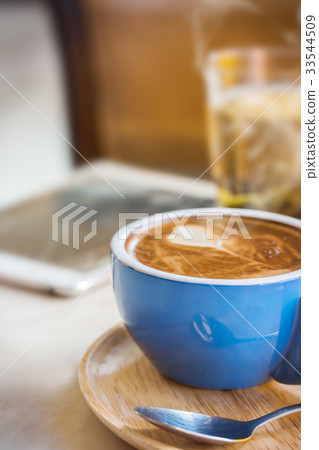 Close up coffee cup with steam on table in cafe. Close up coffee cup with steam on table in cafe. 33544509