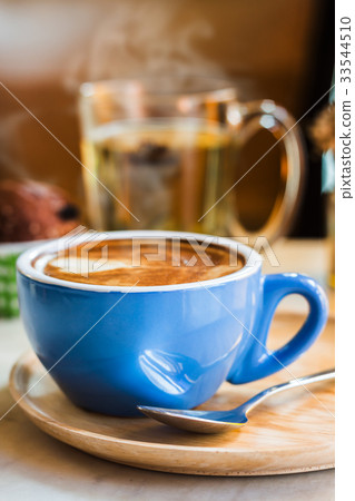 Close up coffee cup with steam on table in cafe. Close up coffee cup with steam on table in cafe. 33544510