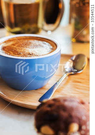 Close up coffee cup with steam on table in cafe. 33544511
