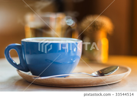 Close up coffee cup with steam on table in cafe. Close up coffee cup with steam on table in cafe. 33544514