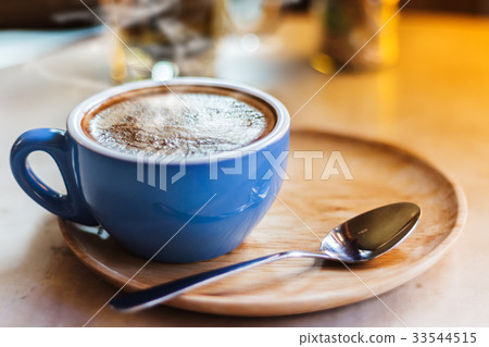 Close up coffee cup with steam on table in cafe. Close up coffee cup with steam on table in cafe. 33544515