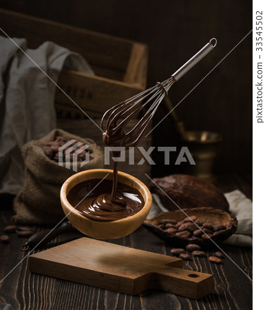 Dark still life with melted chocolate in wooden Dark still life with melted chocolate in wooden 33545502