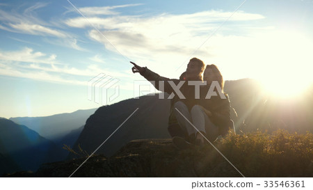 Young couple of tourists resting on the top of the Young couple of tourists resting on the top of the 33546361