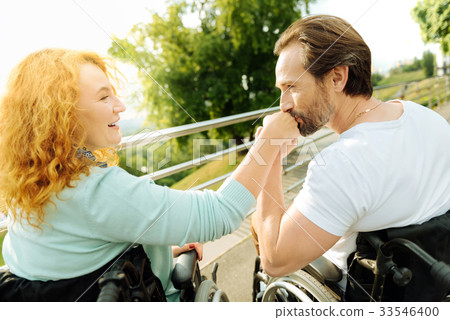Senior disabled man kissing a hand of his loving 33546400