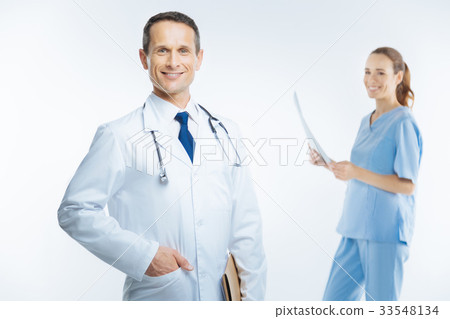 Joyful physician in white coat beaming into camera 33548134