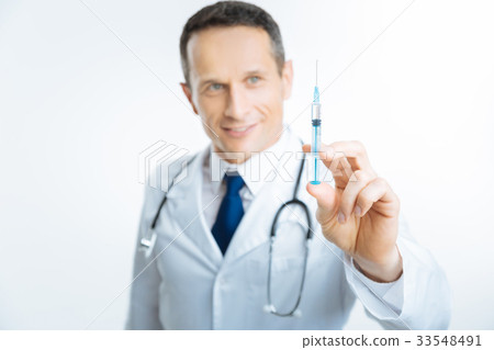 Syringe with vaccine held by cheerful medical Syringe with vaccine held by cheerful medical 33548491