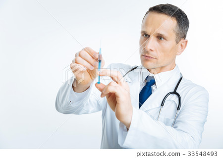 Serious practitioner getting ready for injection Serious practitioner getting ready for injection 33548493