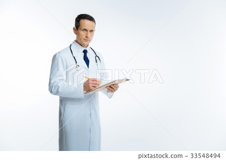 Mature medical worker posing while making notes 33548494