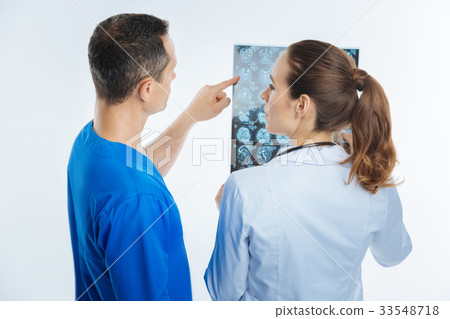 Turned back colleagues discussing mri scan image Turned back colleagues discussing mri scan image 33548718