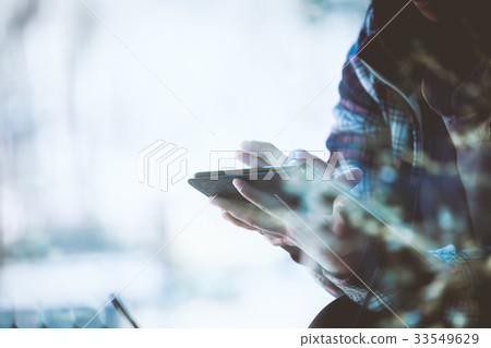 Close-up of woman's hand using tablet in cafeteria Close-up of woman's hand using tablet in cafeteria 33549629