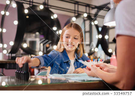 Teenage girl choosing nail polish bottle for Teenage girl choosing nail polish bottle for 33549757