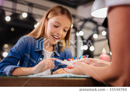 Cheerful girl choosing her future nail color from Cheerful girl choosing her future nail color from 33549760