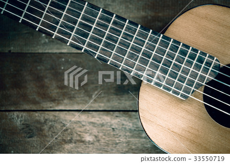 Part of guitar on wooden background 33550719