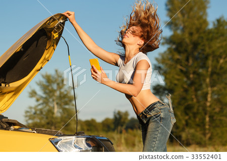 Girl repairing car and on phone 33552401