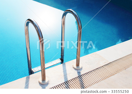 Grab bars ladder in the blue swimming pool 33555250