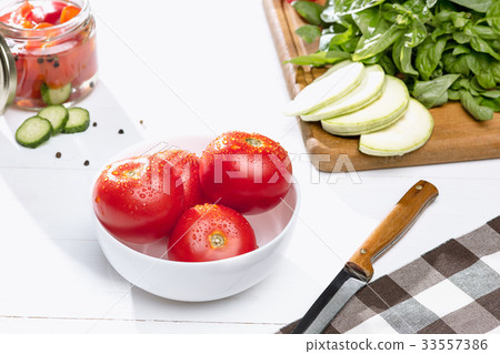 Canned tomatoes and fresh tomato on white 33557386