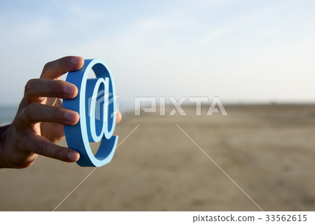 young man with an at sign in his hand 33562615