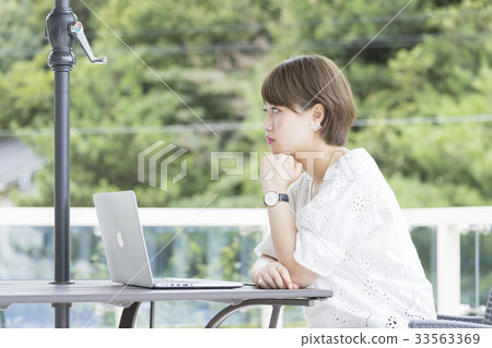 打開在別墅的陽台的女孩一台膝上型計算機 33563369