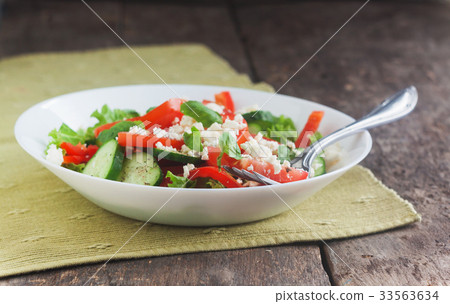 Shopska salad in a white plate on a wooden backgr 33563634