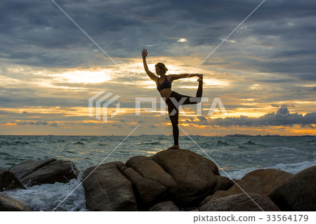 Young woman practicing yoga at the beach Young woman practicing yoga at the beach 33564179