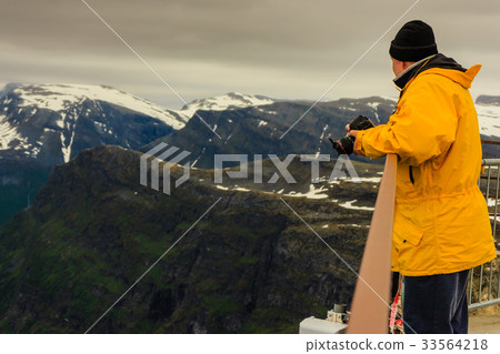 Tourist taking photo from Dalsnibba viewpoint Norway Tourist taking photo from Dalsnibba viewpoint Norway 33564218